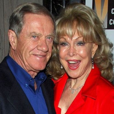 Charles Donald Fegert in on a suit with blue shirt and Barbara Eden is on a red dress.